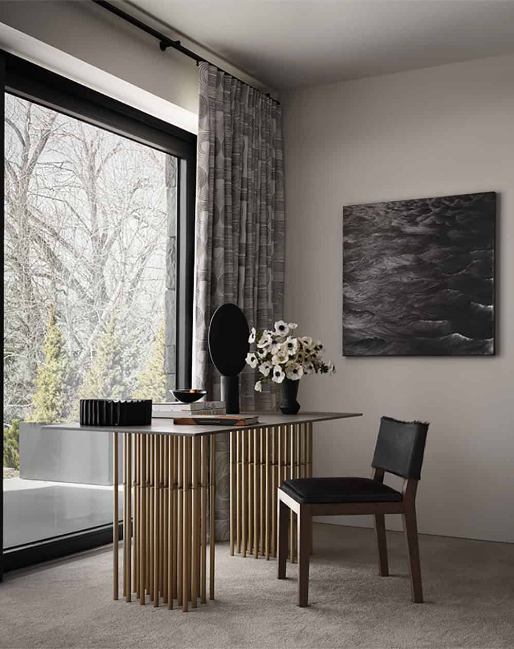 Home office nook with a brass-legged desk, patterned drapes, and a dark wave artwork