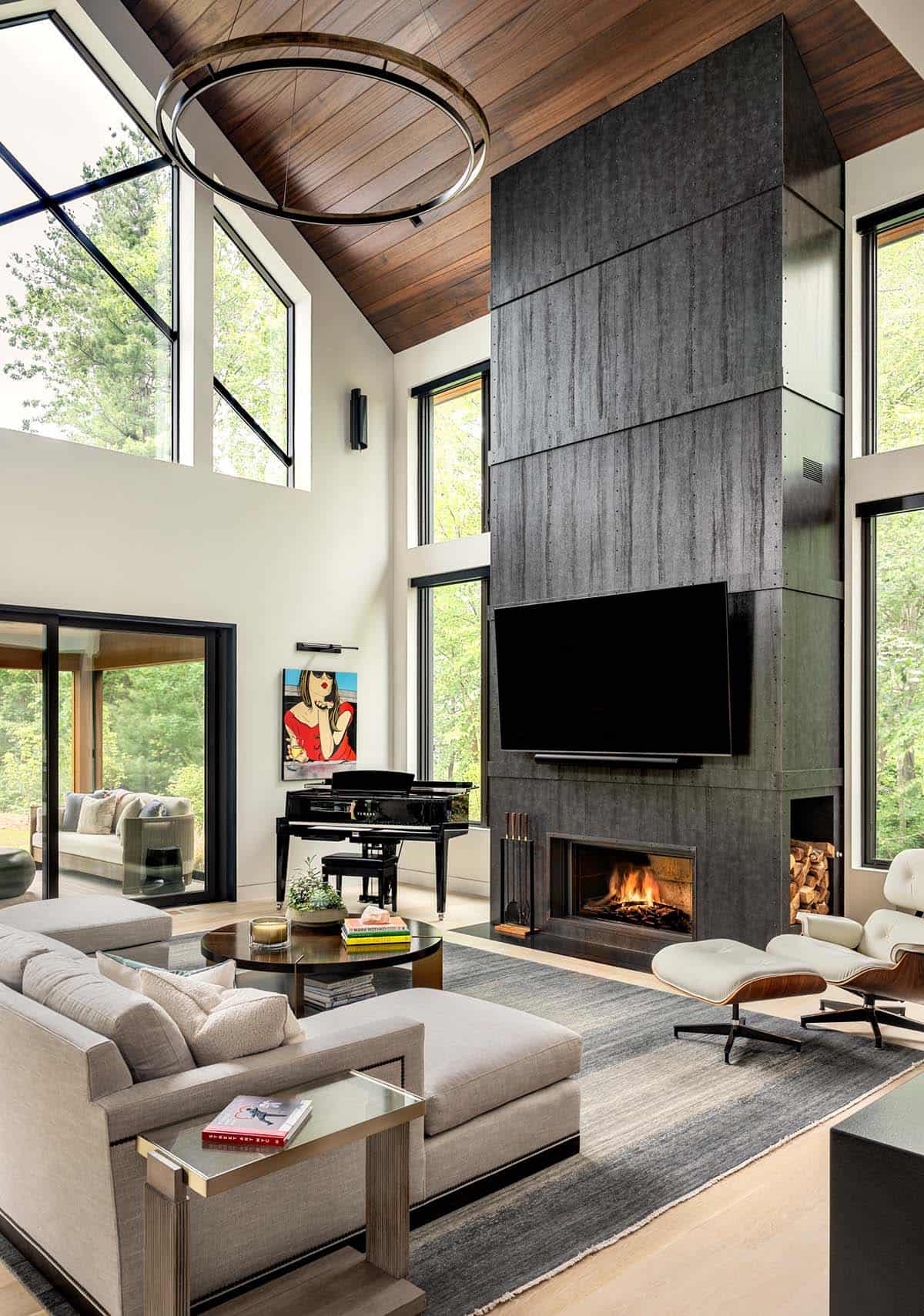 Living room with a vaulted wood ceiling, a black steel fireplace wall, a grand piano, and a ring chandelier