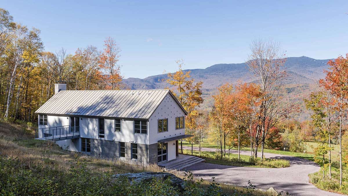 Modern Vermont retreat with metal roof and fall foliage, facing the White Mountains