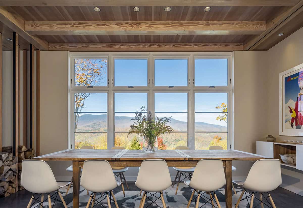 Dining table in front of a large window overlooking the mountains