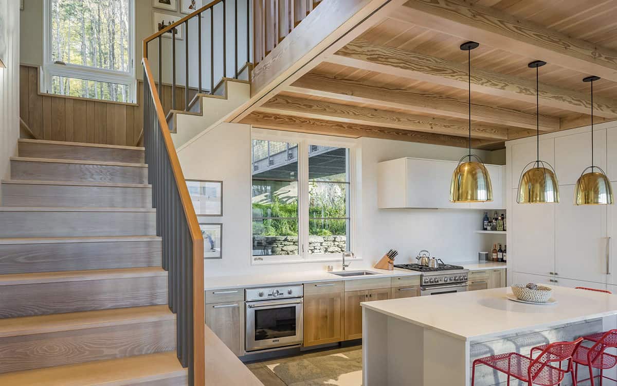 Kitchen and wood staircase beneath a timber-beamed ceiling