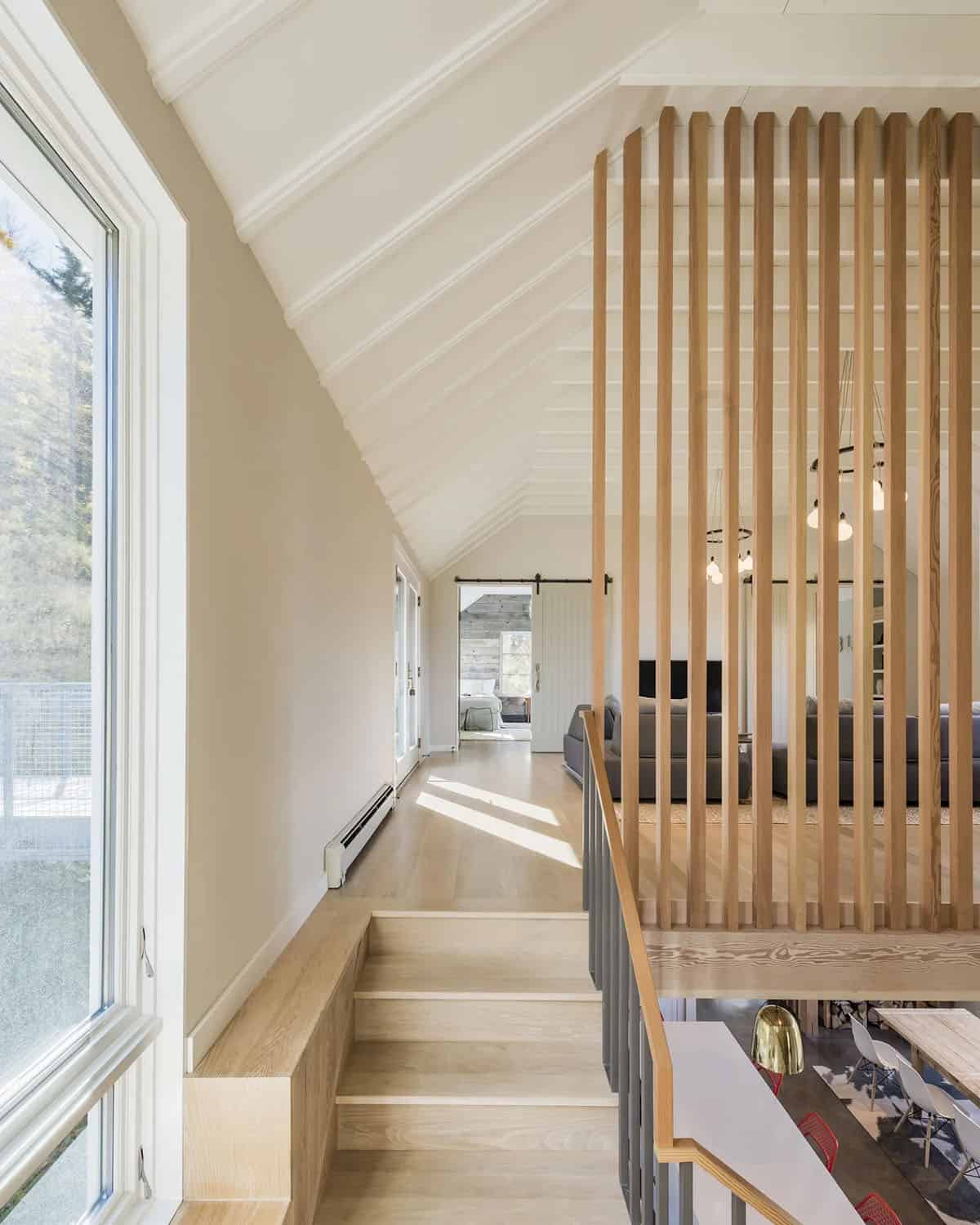 Upper hallway with a vertical timber slat screen and vaulted white ceiling