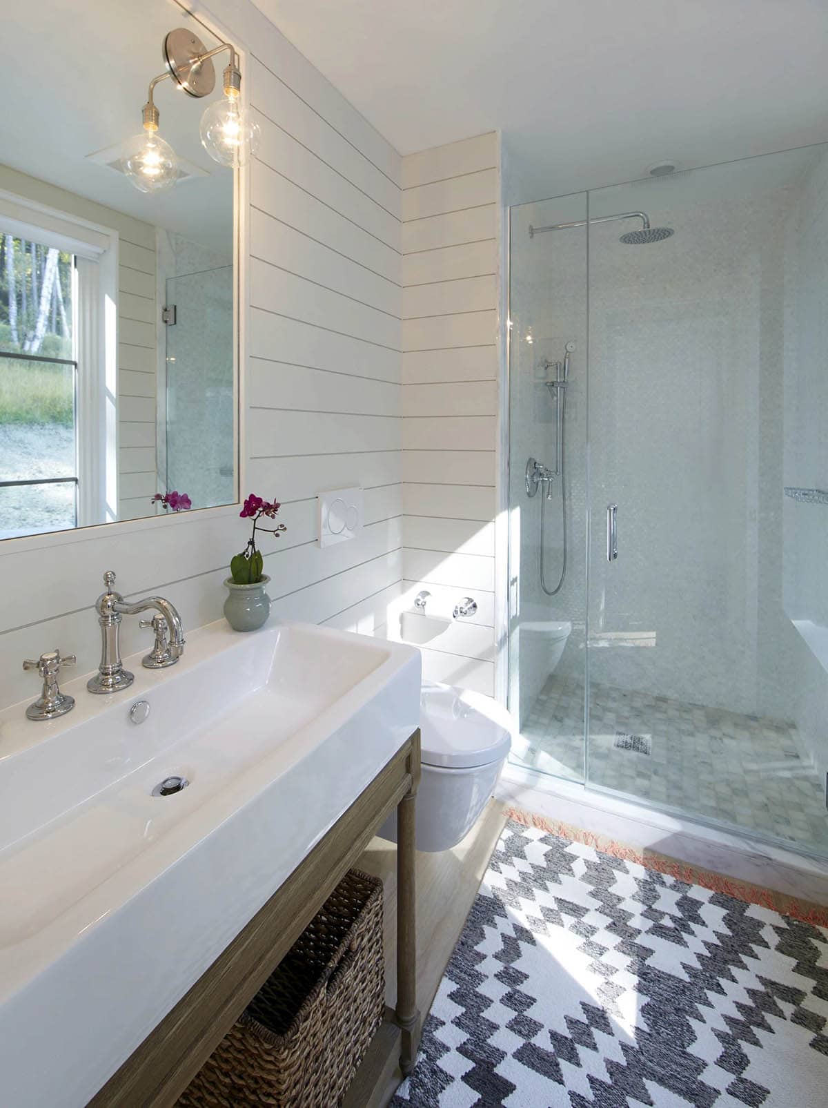 Bathroom with trough sink, shiplap walls and glass-enclosed shower
