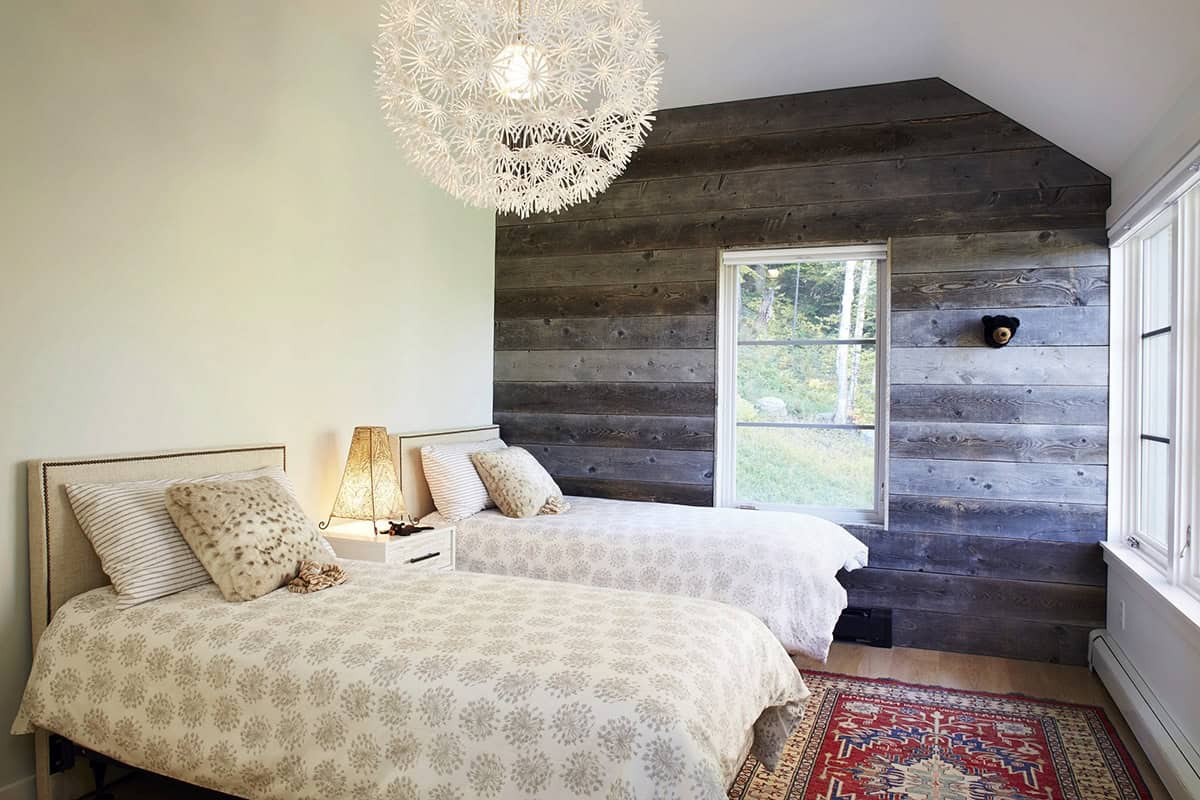 Bedroom with twin beds, reclaimed wood accent wall and a dandelion pendant light