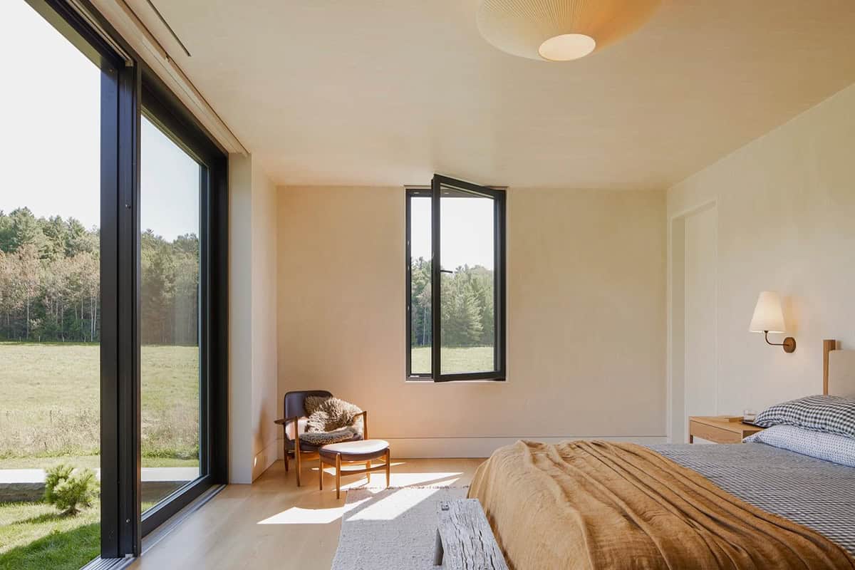 Bedroom with floor-to-ceiling sliding glass door opening to the meadow