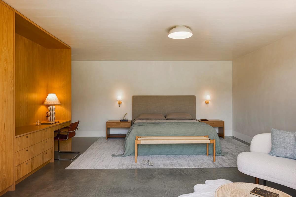 Guest bedroom with built-in oak desk and concrete floor