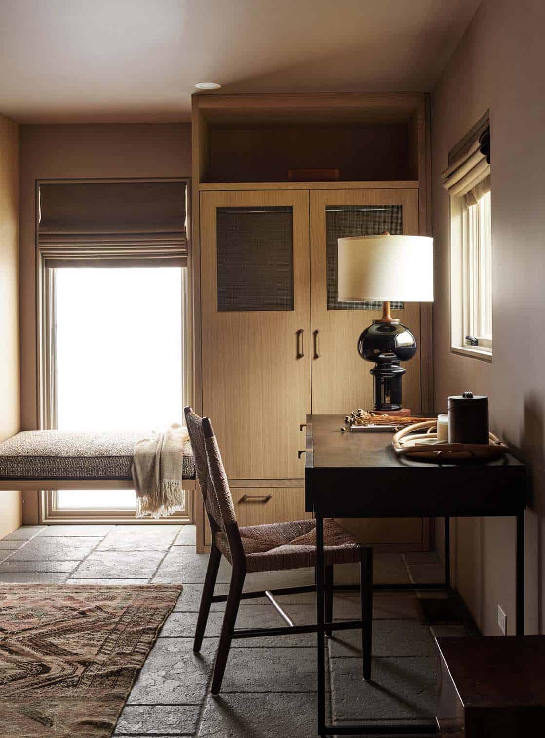 Study nook with cushioned window bench, oak wardrobe, black glass table lamp and dark wood desk