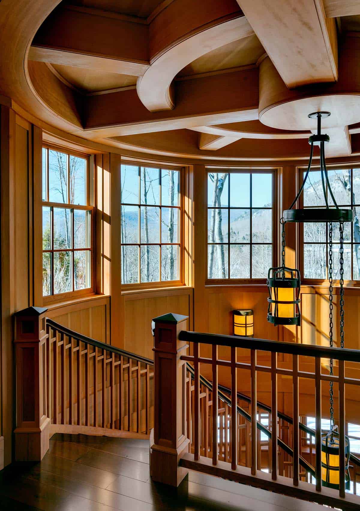 Upper stair landing with a curved coffered ceiling, lantern chandelier and windows framing mountain views