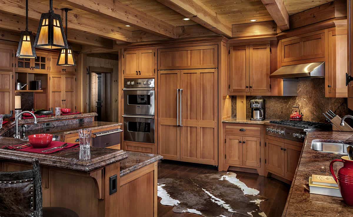 Kitchen with wood Shaker cabinets, granite countertops, double wall ovens, a panel-ready refrigerator and mica pendants