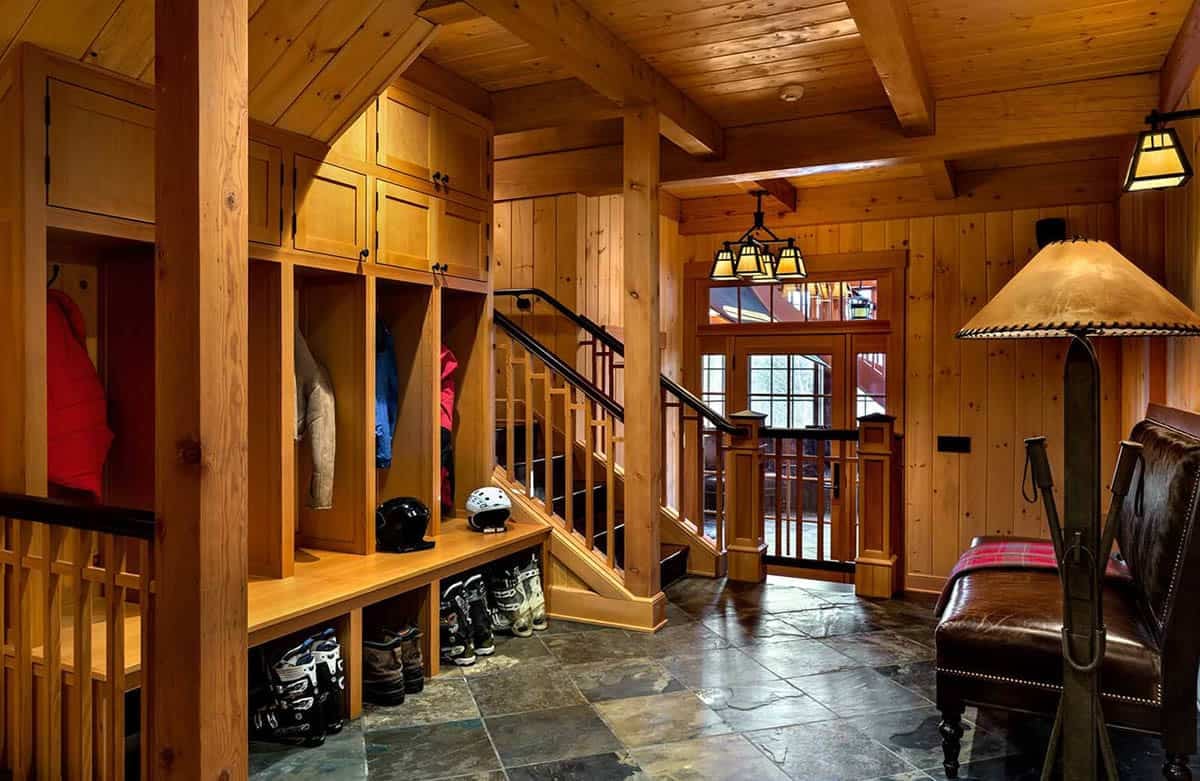 Ski room with built-in cubbies for jackets, helmets and boots, a slate floor and a leather bench