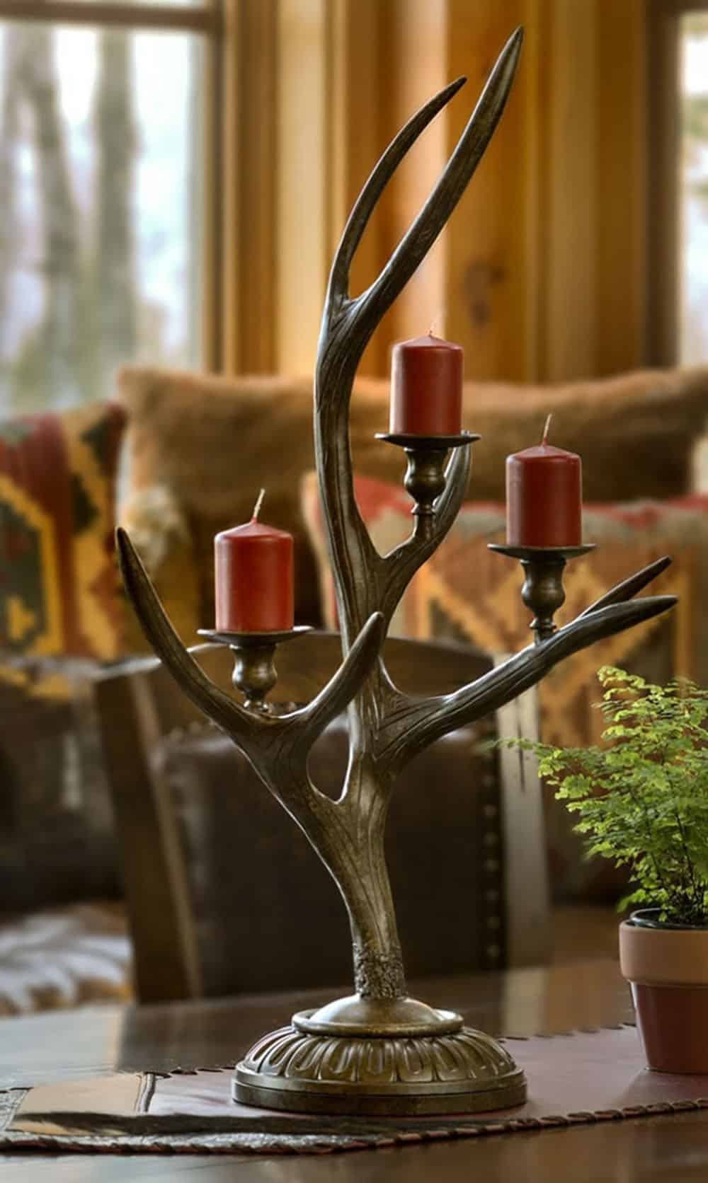 Antler candelabra with three red pillar candles on a dining table