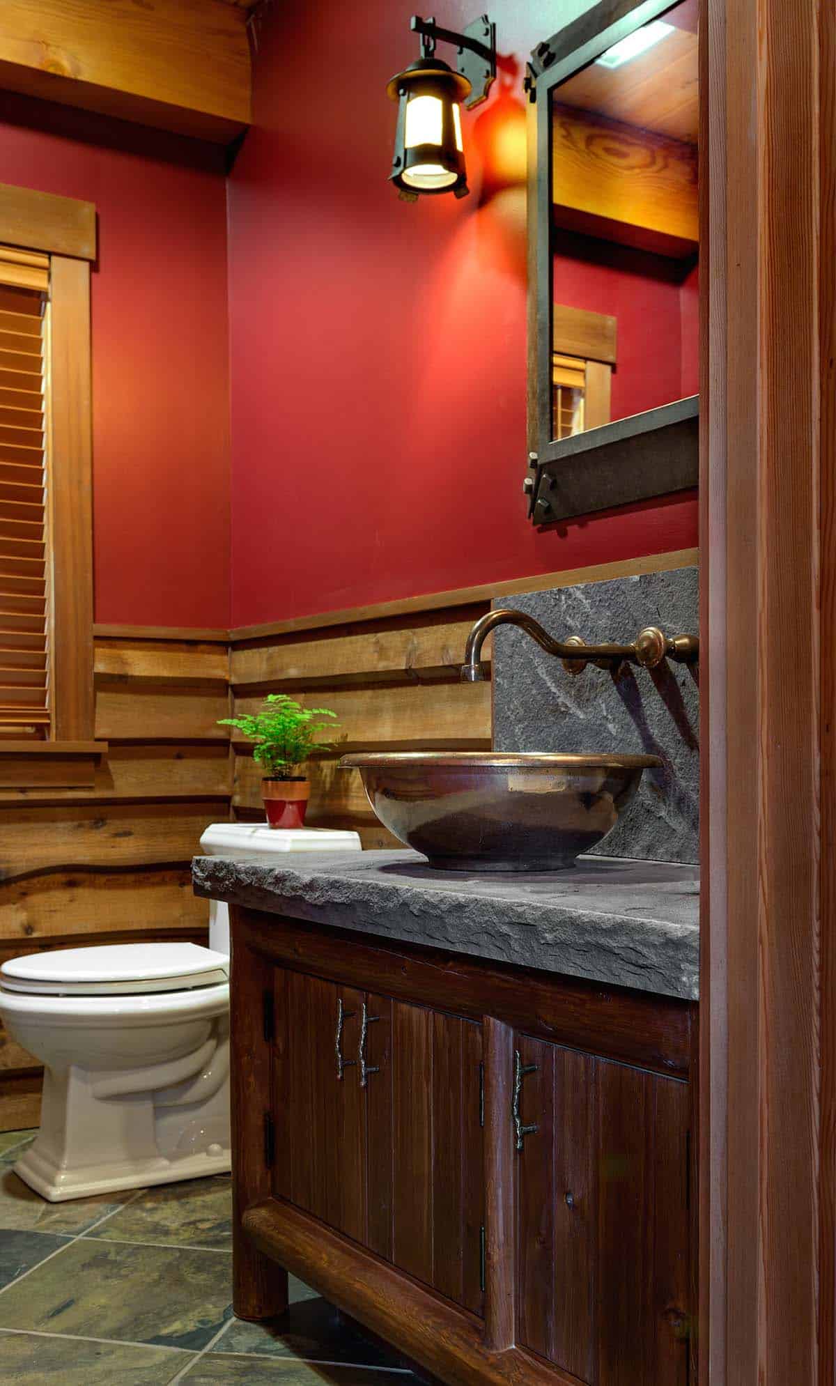 Red powder room with a copper vessel sink on a rough-hewn stone countertop, wall-mount faucet and live-edge wood wainscoting