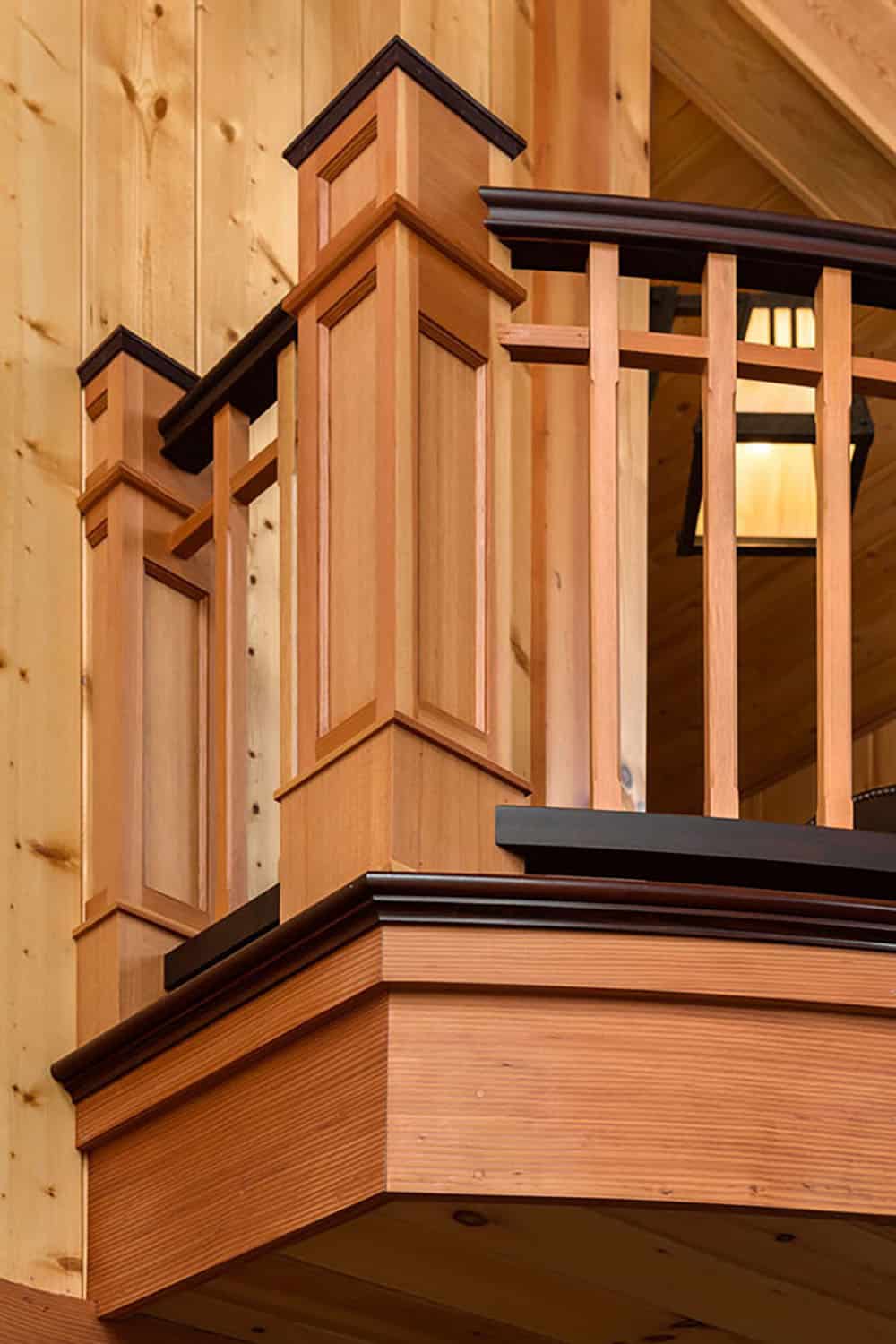 Curved wood balcony with paneled newel posts, square balusters and a dark wood handrail