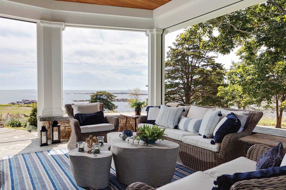 Porch lounge with wicker furniture and rope-wrapped coffee tables, facing the rocky shoreline