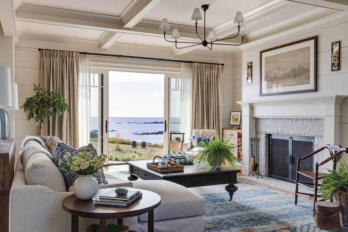 Living room with a coffered ceiling, shiplap walls, granite fireplace, and sliding doors to the ocean view