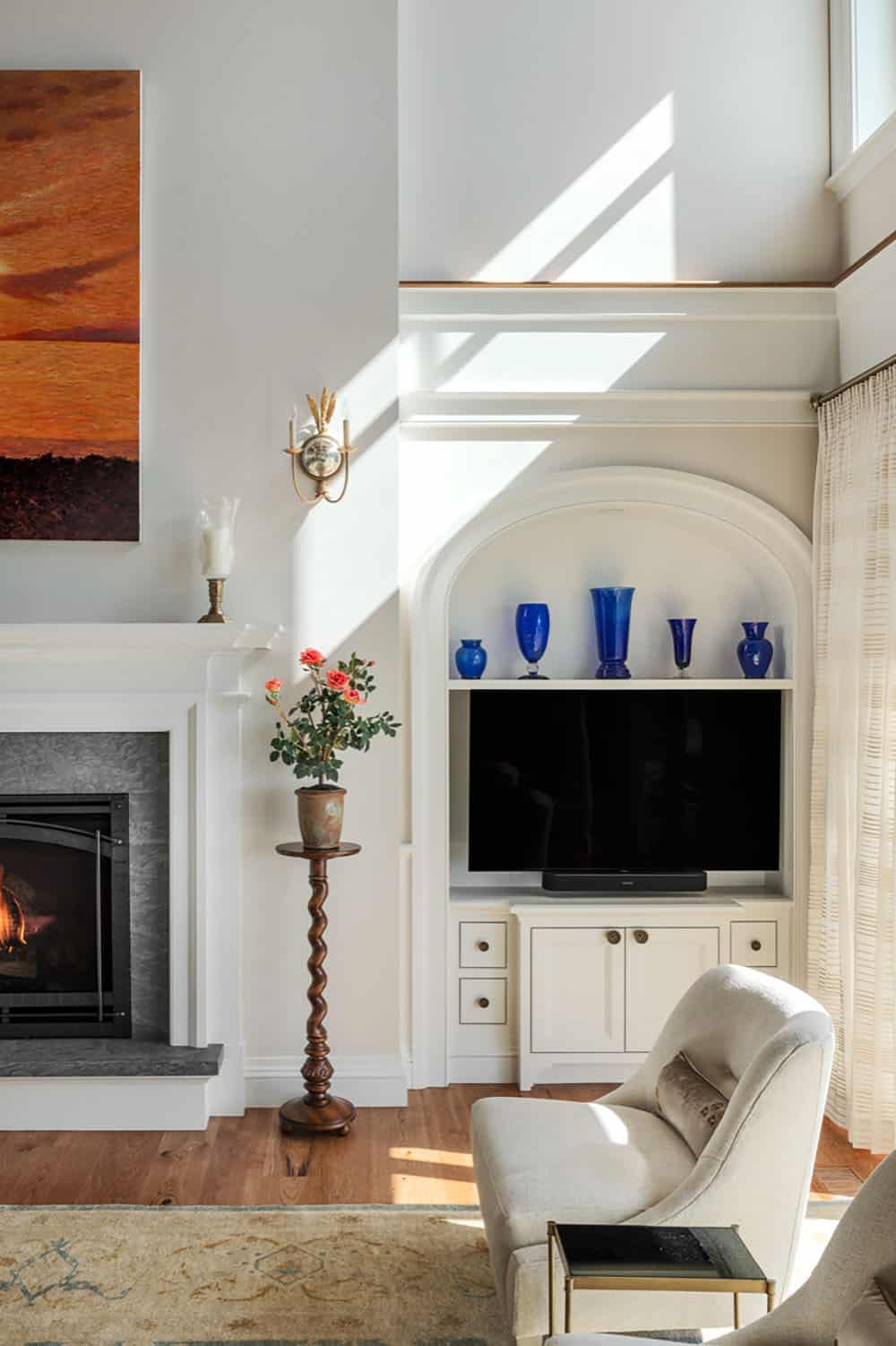 Arched built-in niche with blue glass vases beside the fireplace