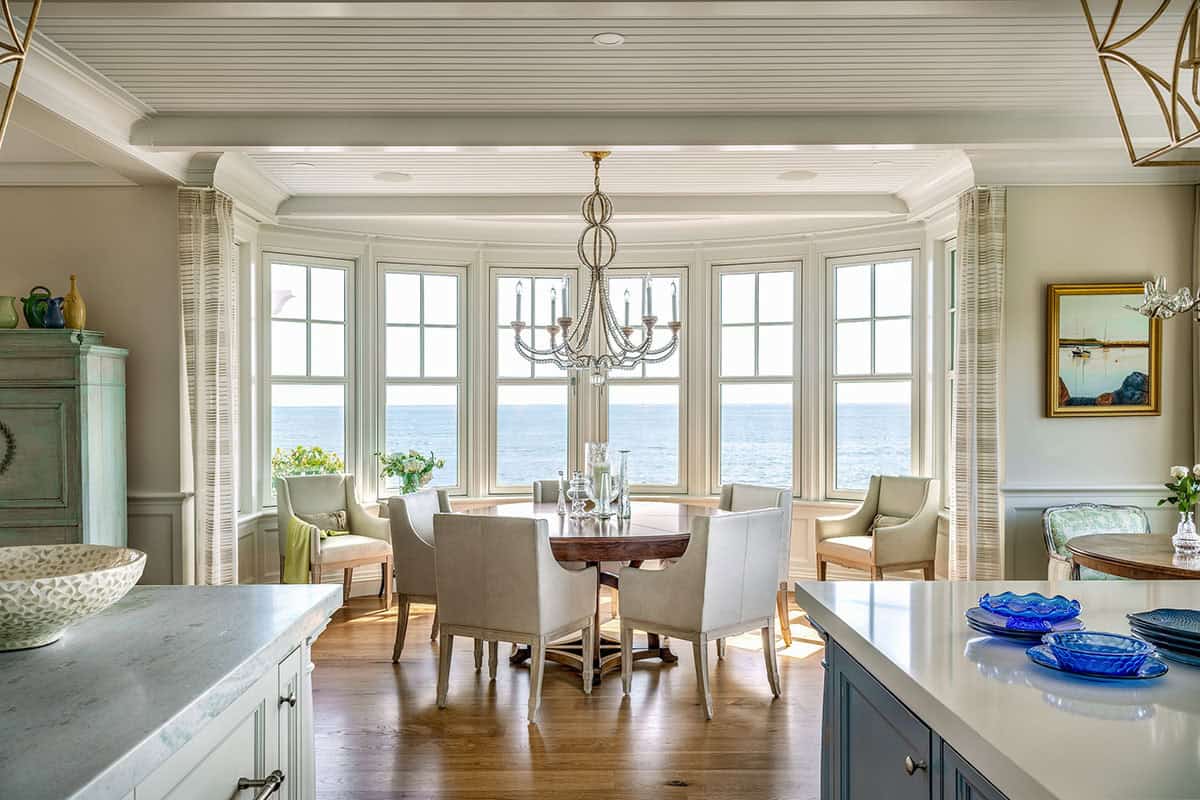 Dining area in a curved window bay, seen from the kitchen, with ocean views