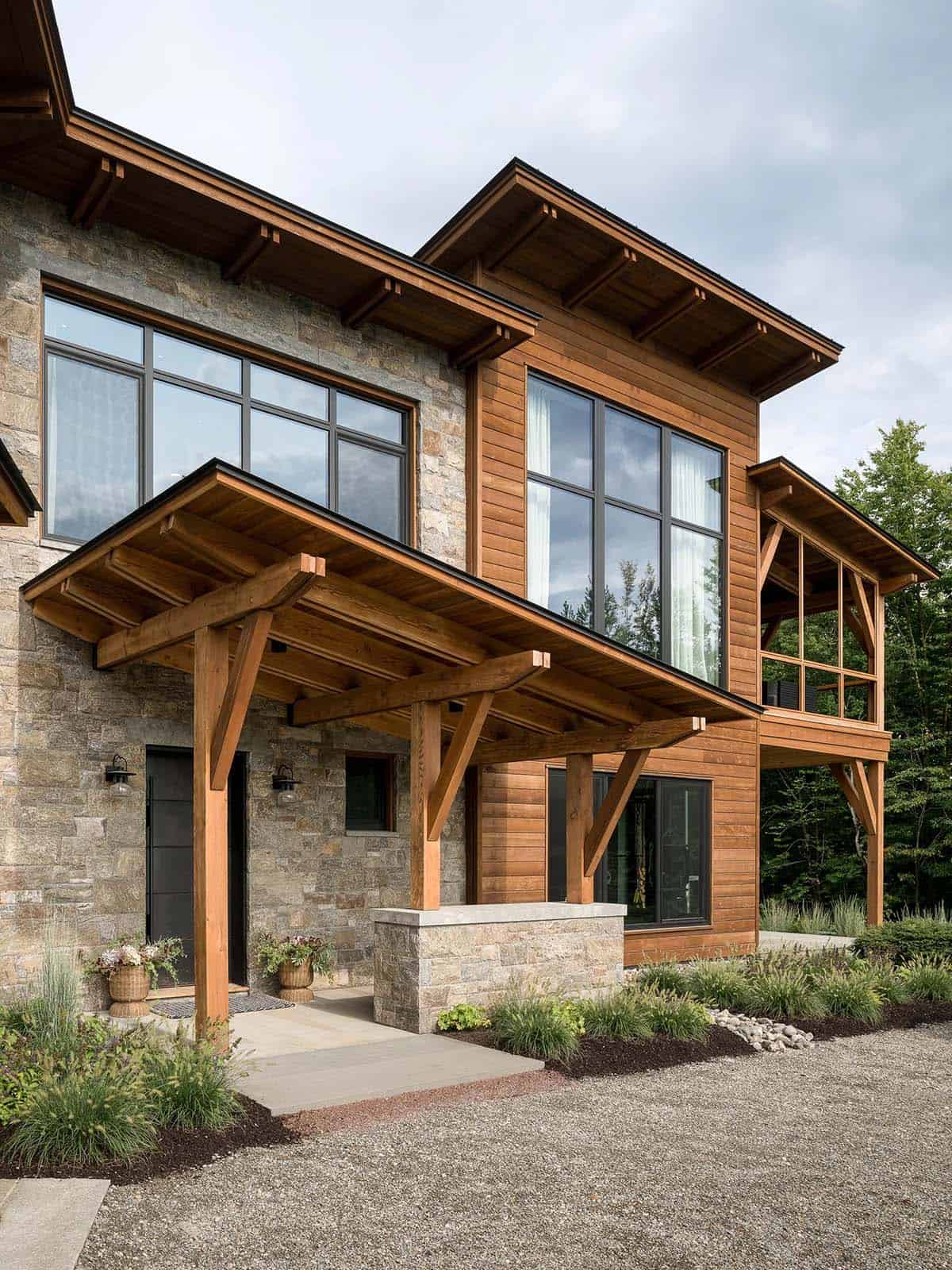 Timber-frame entry portico beside cedar-clad wing and screened porch