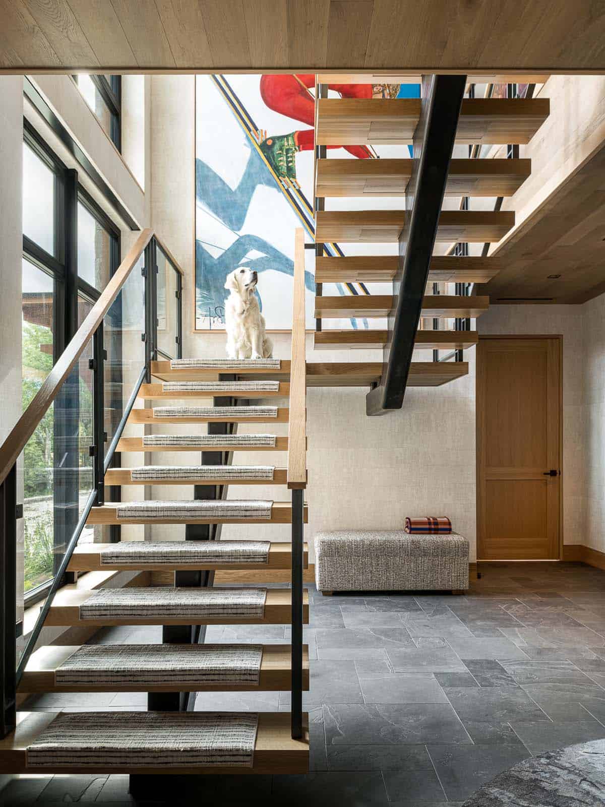 Open-riser staircase with golden retriever below oversized skier painting