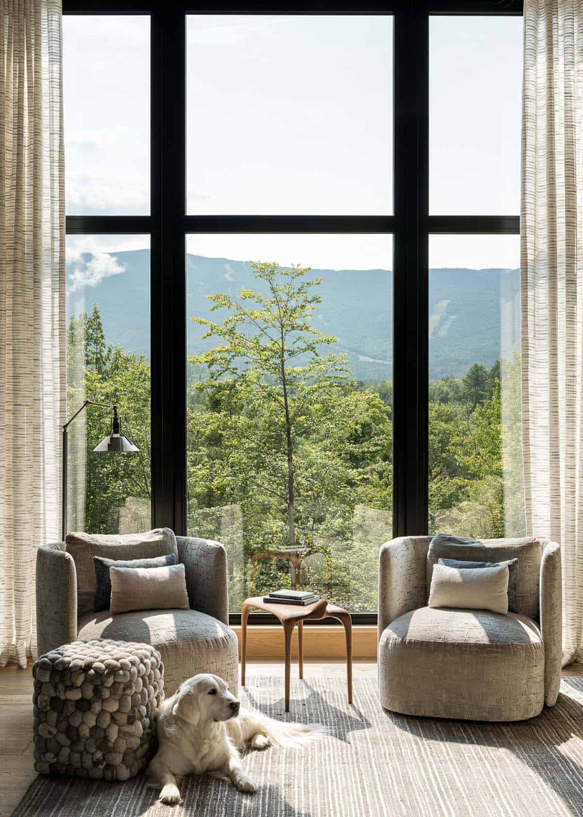 Swivel chairs facing floor-to-ceiling window with ski mountain view