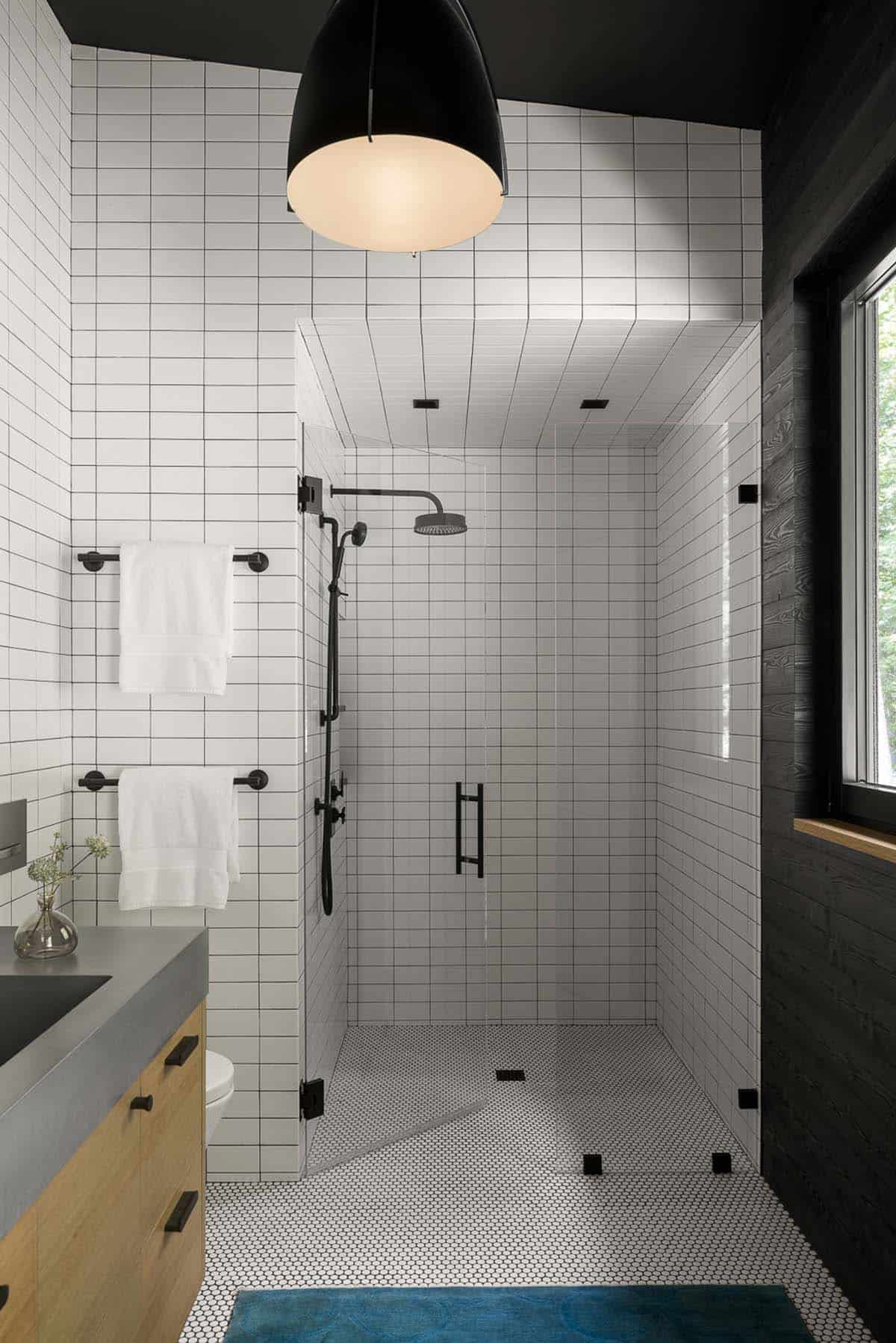 Black and white bathroom with walk-in shower and penny tile floor