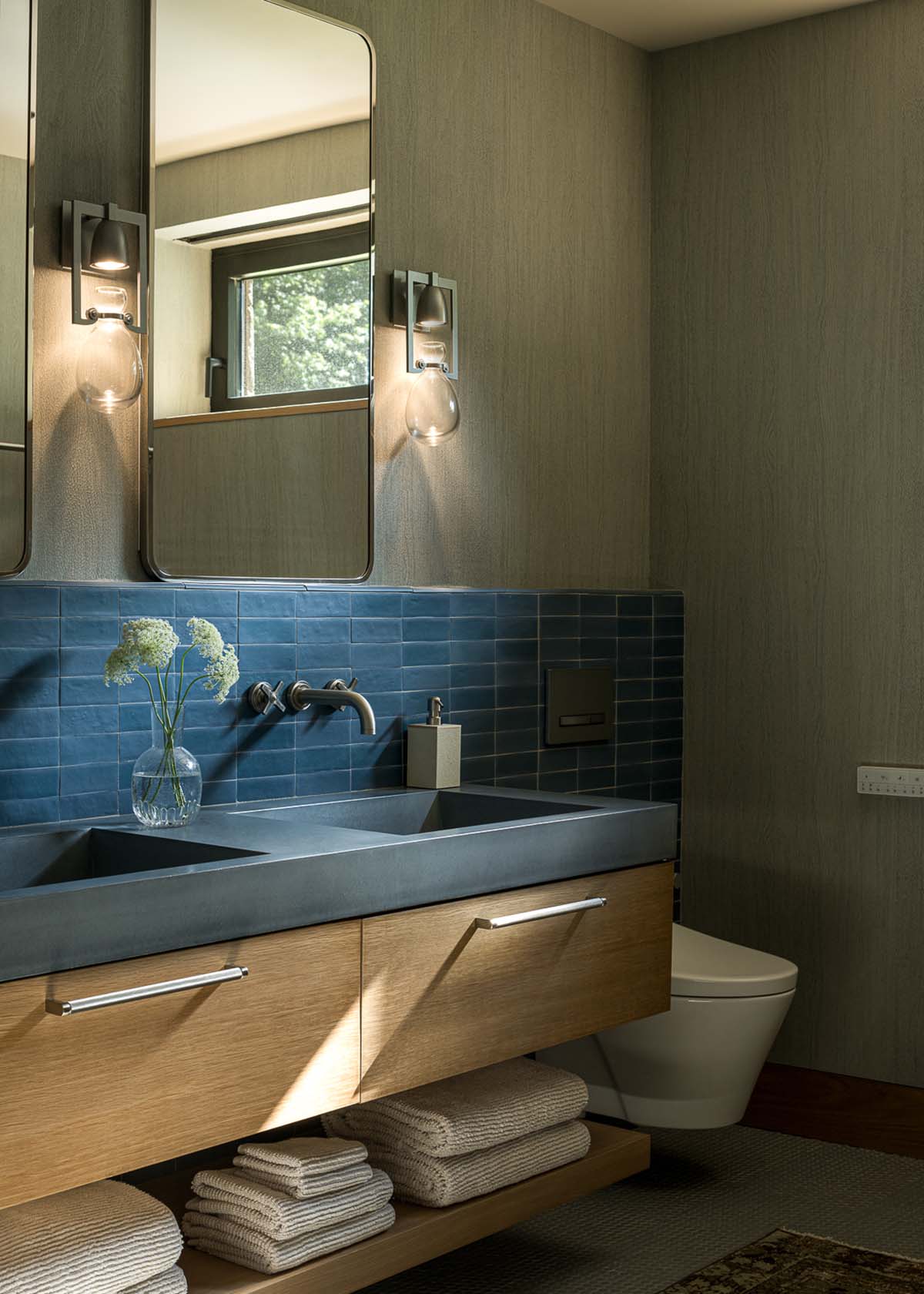 Bathroom vanity with blue concrete double sink and blue tile