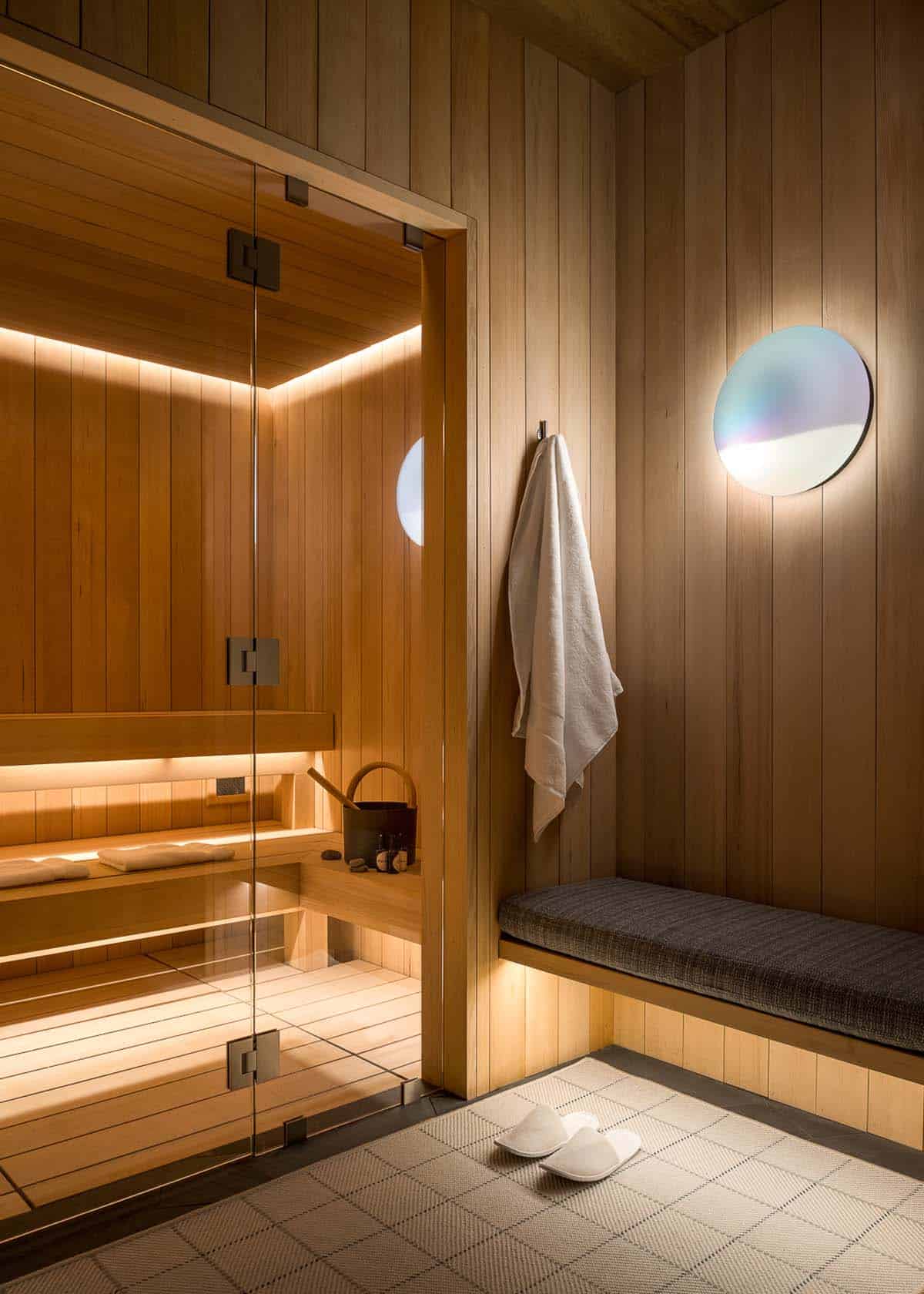 Cedar sauna with glass door and cushioned lounge bench