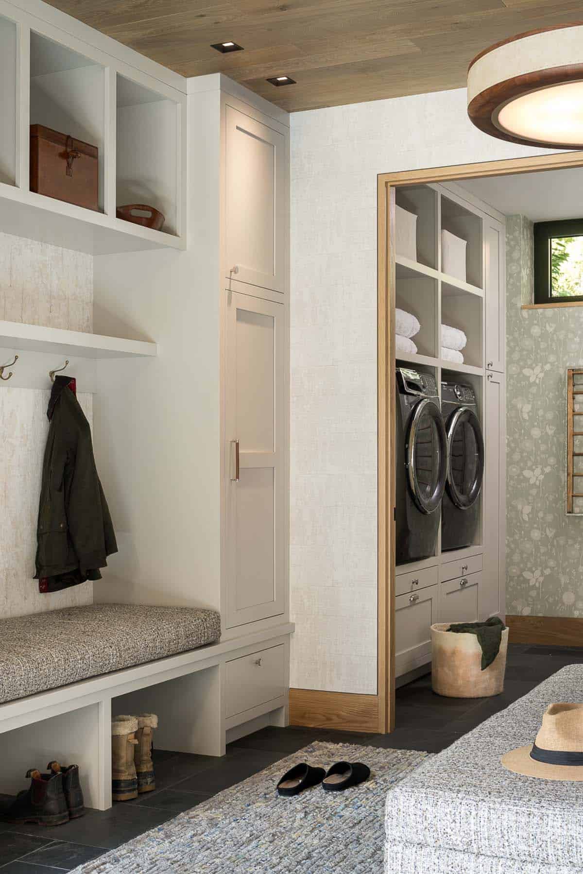 Mudroom with built-in bench and view into laundry room