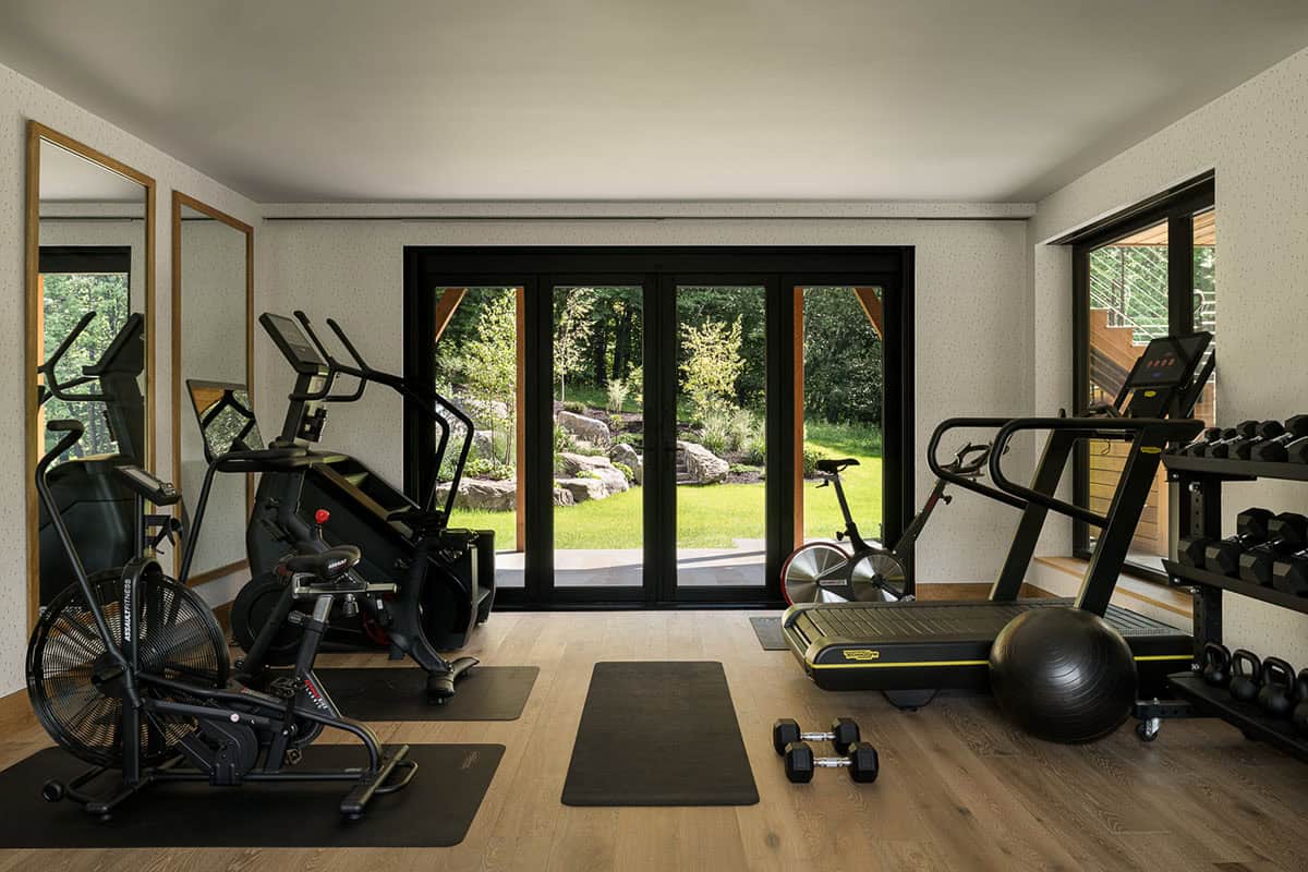 Home gym with fitness equipment and doors to landscaped yard