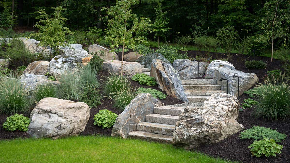 Granite steps winding through boulders into wooded hillside