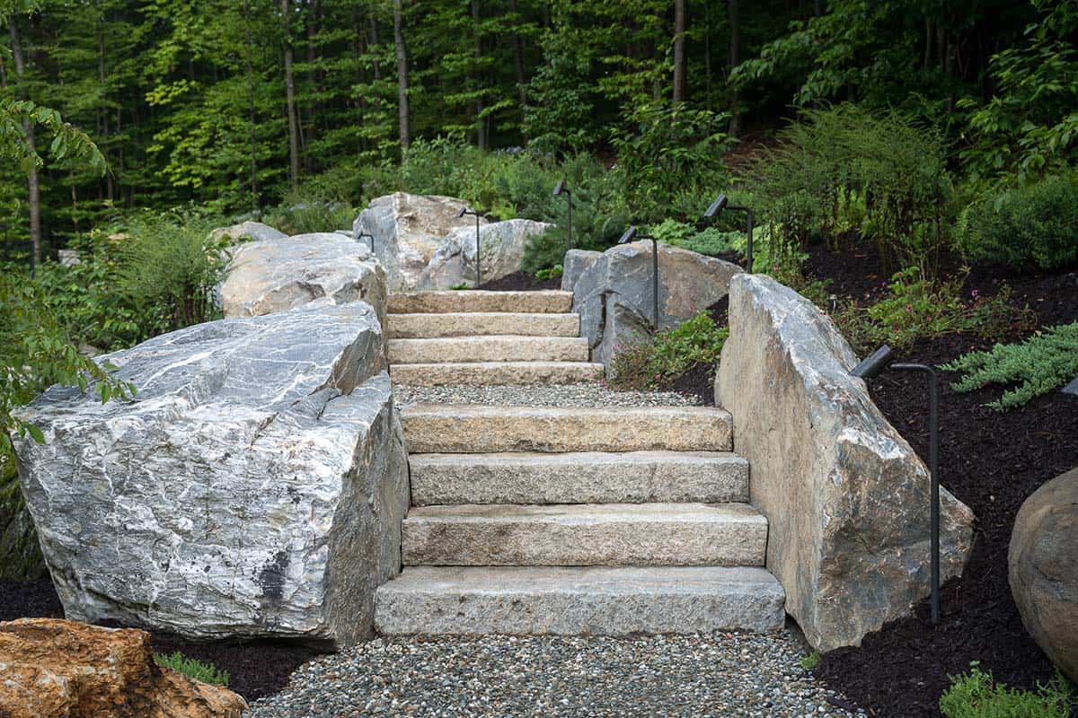 Granite slab steps flanked by boulders and path lights