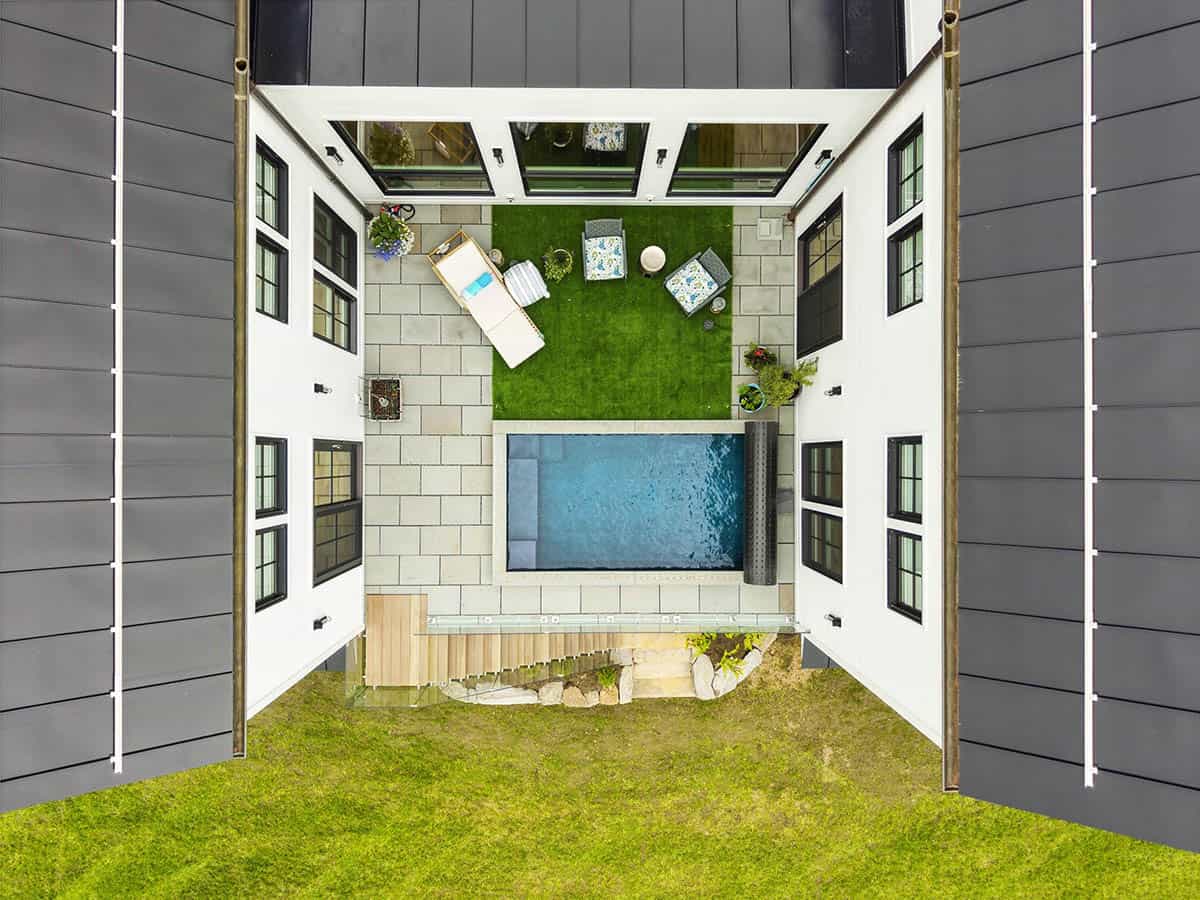 Overhead view of the courtyard between two wings, with a plunge pool, artificial turf lounge area, and stone pavers