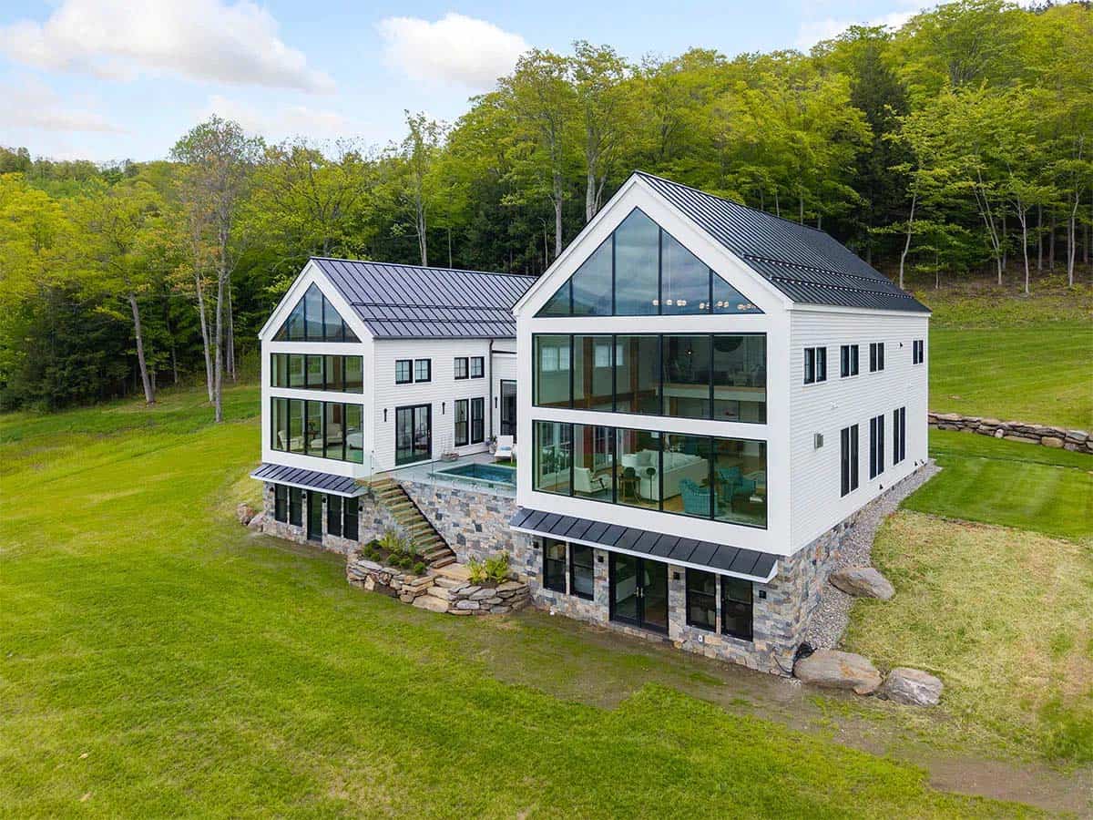 Aerial view of the rear with two glass gables, a stone walkout level, and a plunge pool in the raised courtyard
