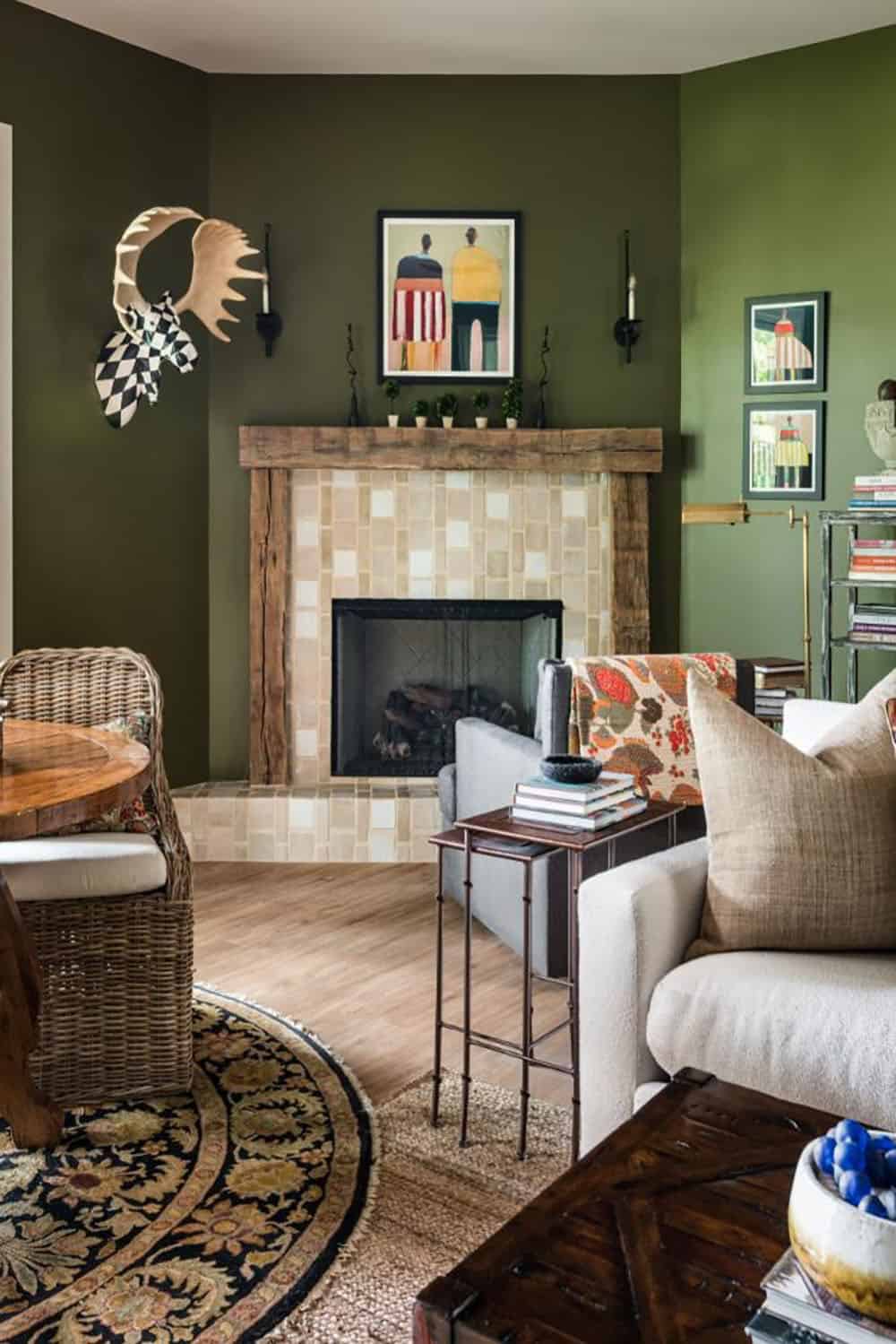 Olive green family room with tiled corner fireplace and reclaimed wood mantel