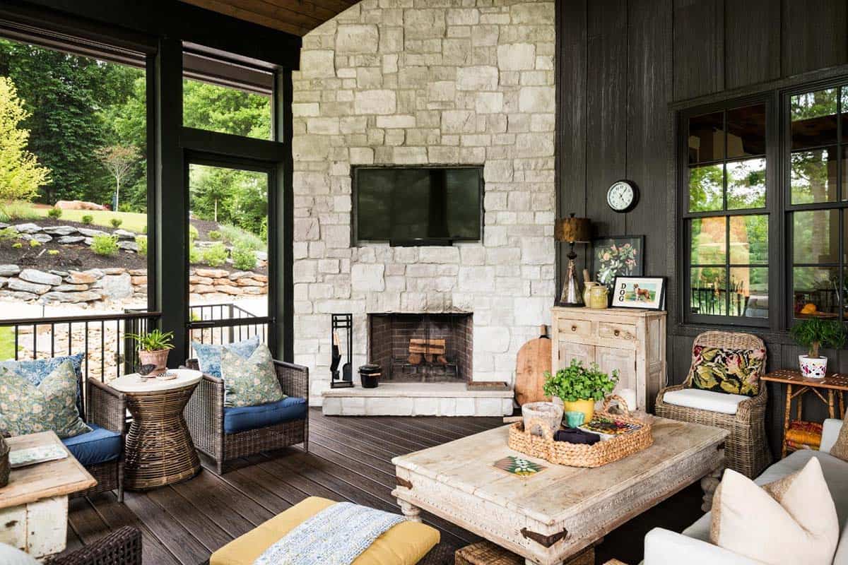 Screened porch with white stone fireplace, TV and carved coffee table