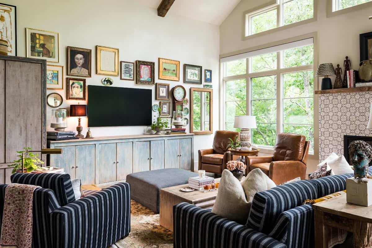 Great room gallery wall above a painted blue console with leather recliners