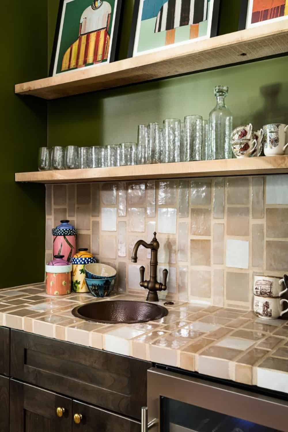Close-up of wet bar with handmade tile, copper sink and bronze faucet