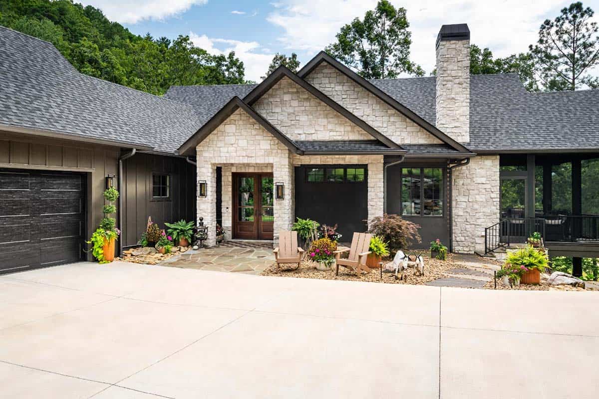 Front facade with white stone entry, dark board and batten and garage door