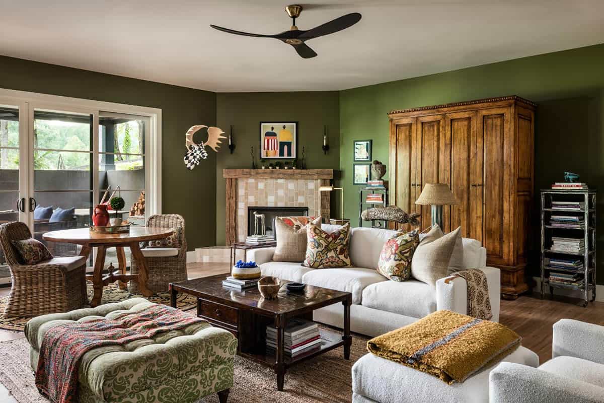 Olive green family room with white sofa, wood armoire and corner fireplace