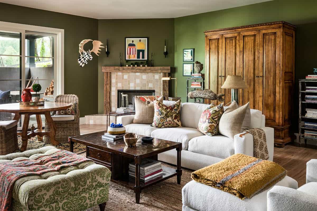 Family room with olive walls, tufted green ottoman and antique armoire