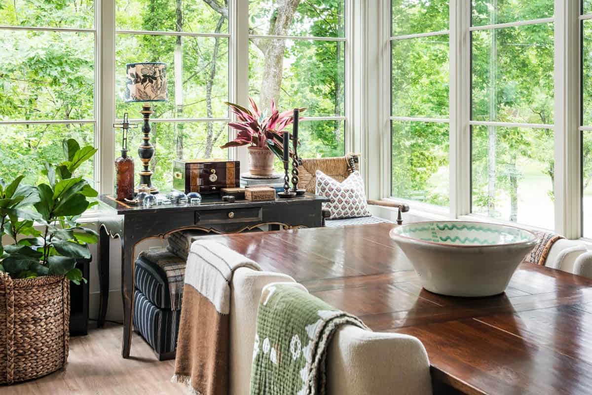 Dining area with black console table and corner windows overlooking trees