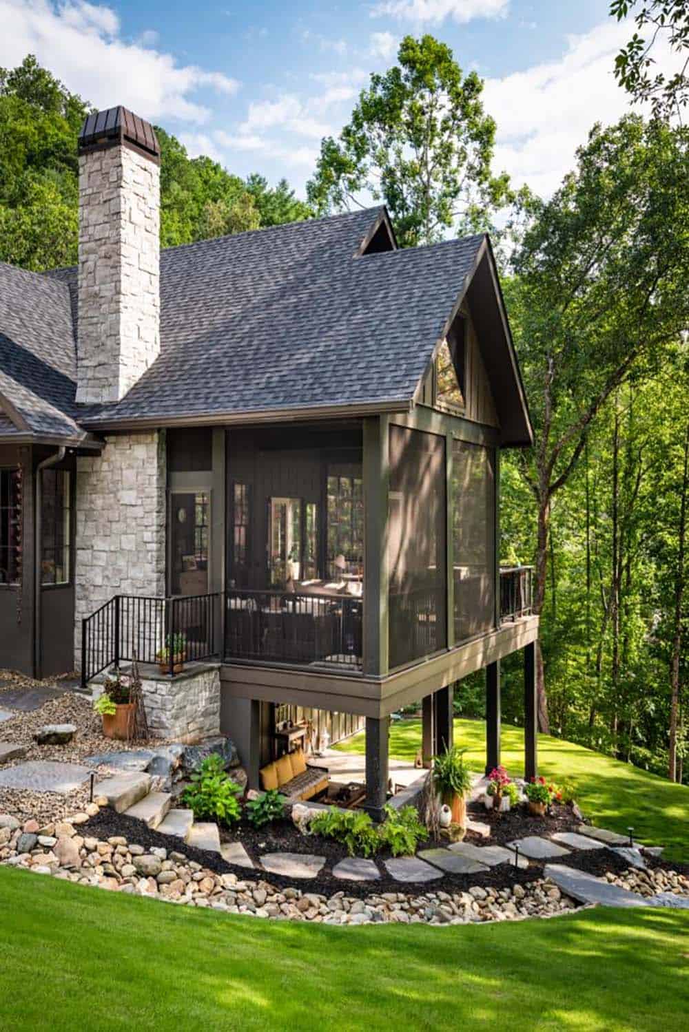 Rear exterior with elevated screened porch, stone chimney and flagstone path
