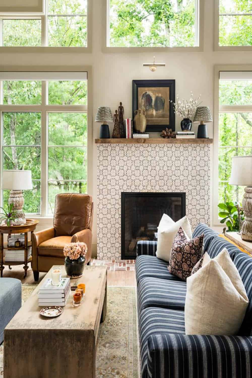 Great room fireplace with patterned tile surround and wood mantel