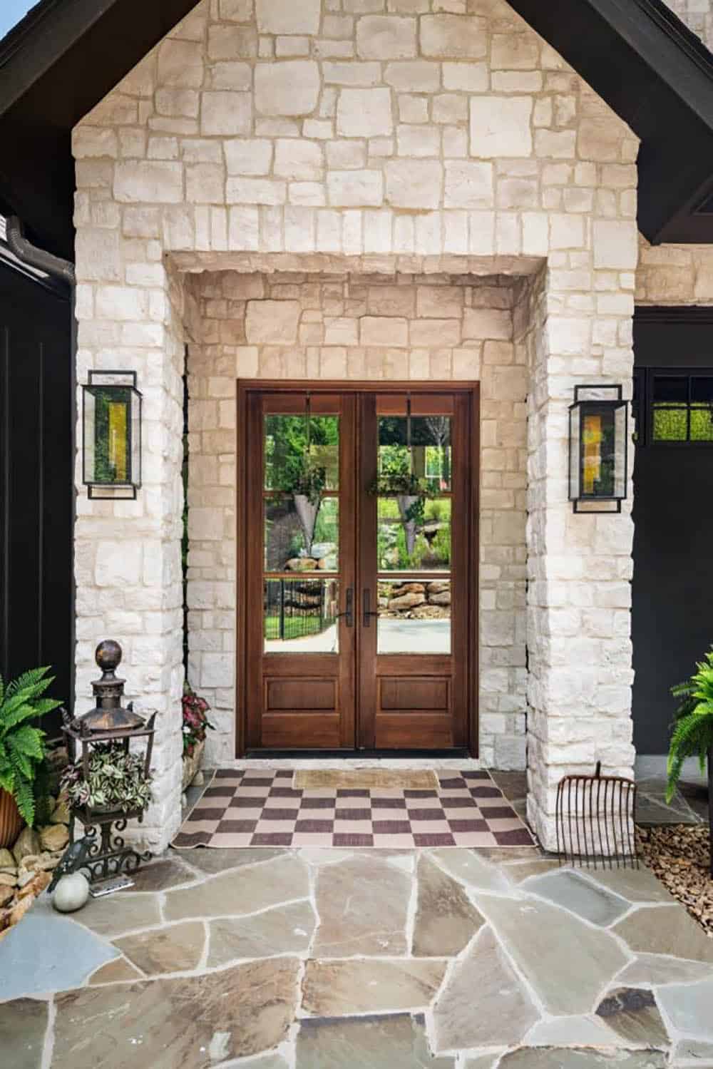 Wood double doors set in a white stone entry portico