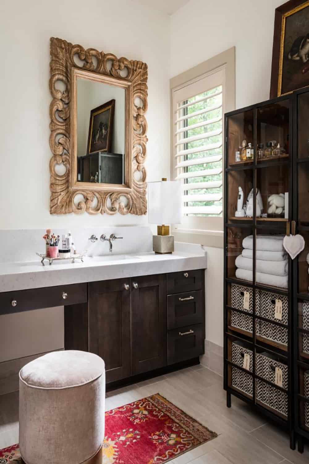 Bathroom vanity with carved mirror, velvet stool and glass storage cabinet