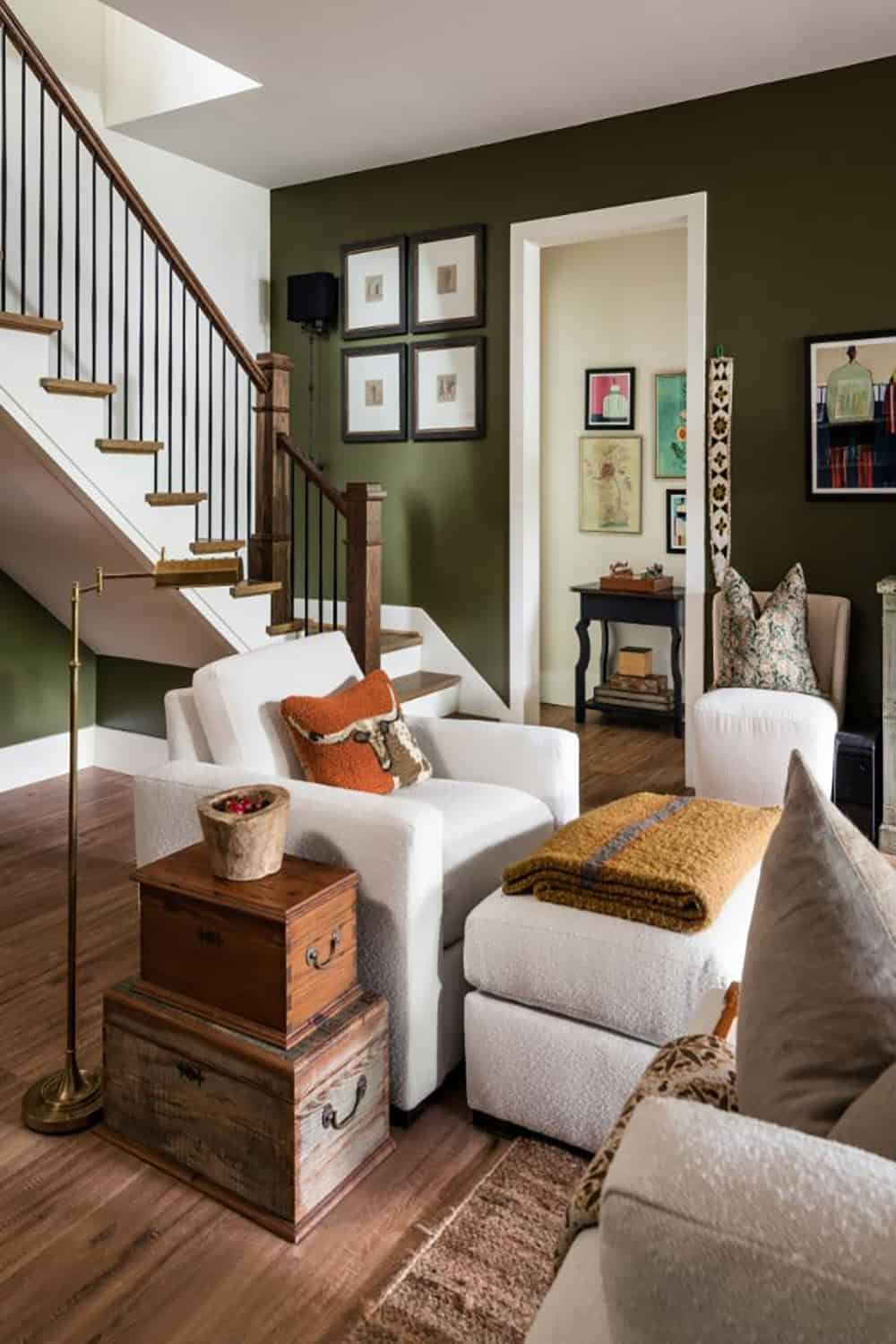Family room with olive walls, white armchair and staircase