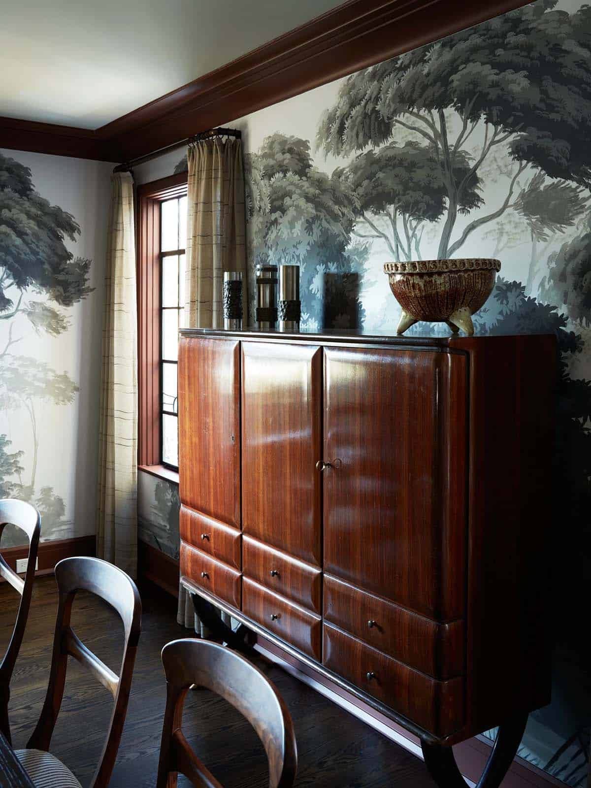 Mahogany cabinet with ceramic bowl against gray tree mural