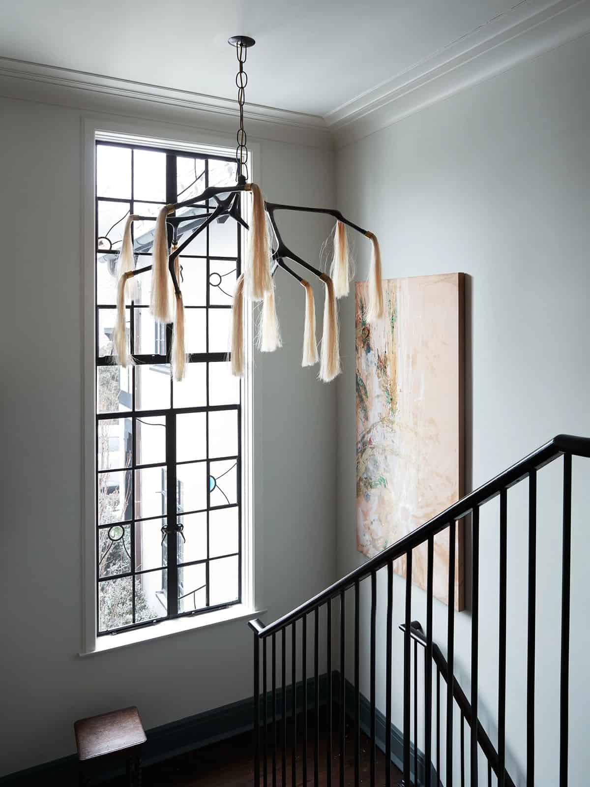 Upper landing with horsehair chandelier and tall leaded glass window