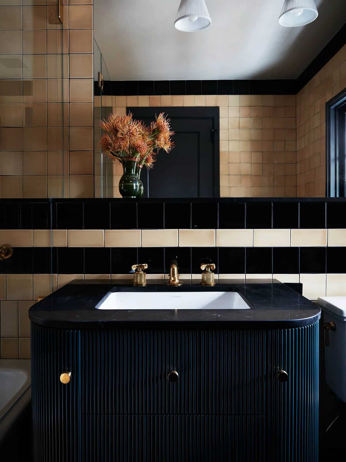 Bathroom with black fluted vanity and peach and black tile